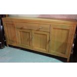 A modern oak sideboard with single central drawer over cupboard doors,
