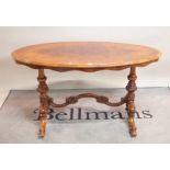 A Victorian style walnut oval centre table on four outswept suports,