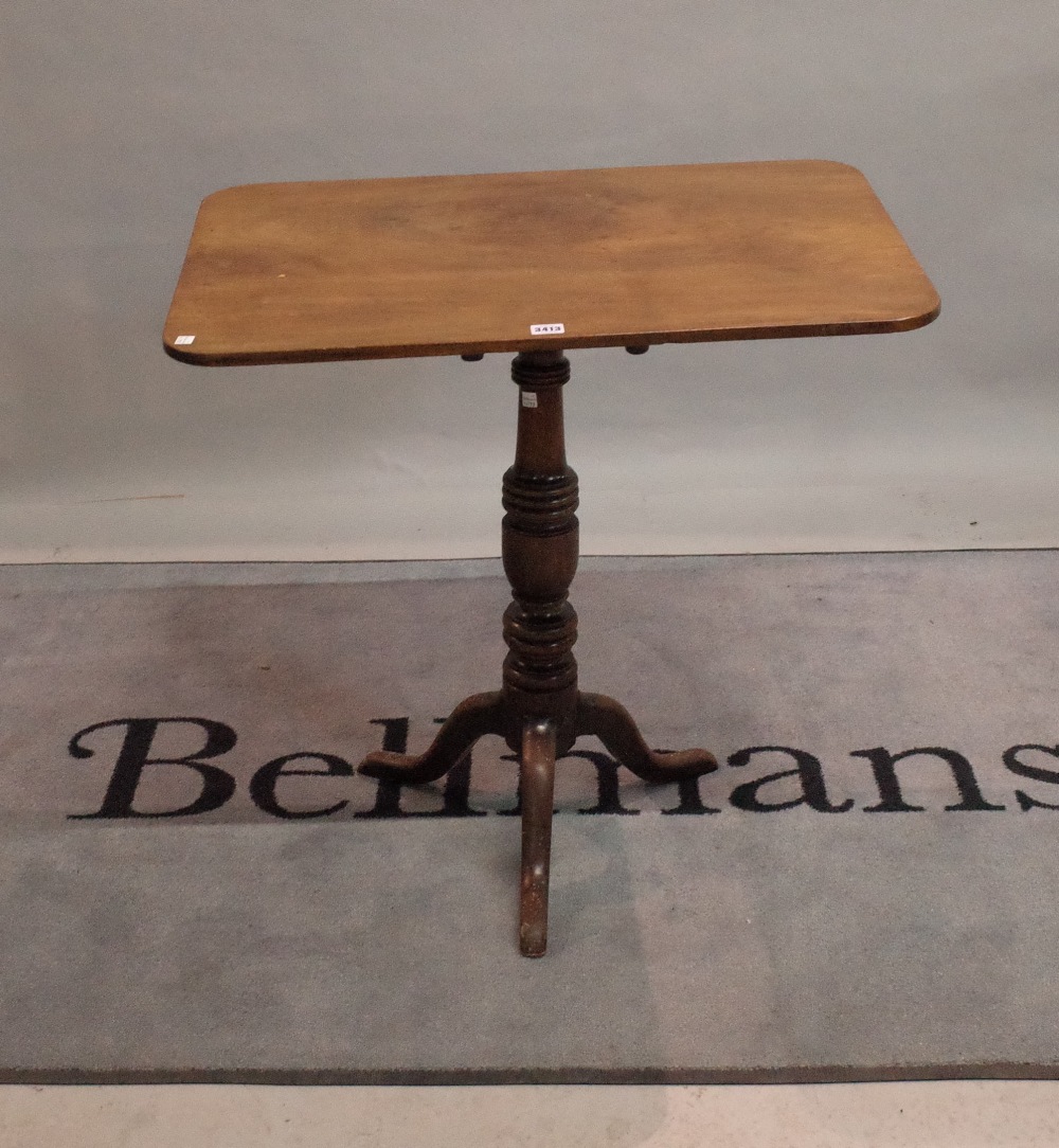 A Victorian mahogany tripod table with rectangular top on turned column and outswept supports,