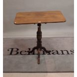 A Victorian mahogany tripod table with rectangular top on turned column and outswept supports,