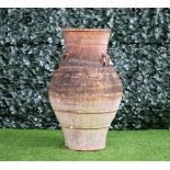 A large terracotta oil jar, with ribbed body and three lug handles, 100cm high x 50cm diameter.