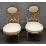 A pair of gilt framed side chairs, with oval padded backs on turned supports,