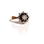 A gold, diamond and sapphire cluster ring, mounted with a circular cut diamond to the centre,