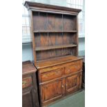 An elm dresser, 18th century, with two drawers and a cupboard below,