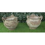 A pair of reconstituted stone tyg style jardinieres with three loop handles and floral moulded body,