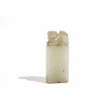 A Chinese pale celadon jade seal, Qing Dynasty, surmounted by a Buddist lion, 6.5cm. high.