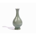 A small Chinese celadon glazed porcelain vase, Qing dynasty, of slender pear form with waisted neck,