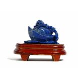 A Chinese lapis lazuli carving, depicting a chilong clambering on a flower or fruit, 8.75cm.