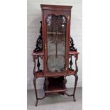 An Art Nouveau foliate carved mahogany floor standing corner cabinet, enclosed by a glazed door,