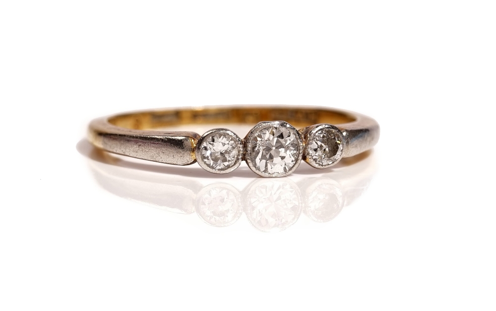 A gold and platinum, diamond set three stone ring,