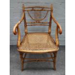 A Regency polychrome painted faux bamboo open armchair with cane seat on turned supports,