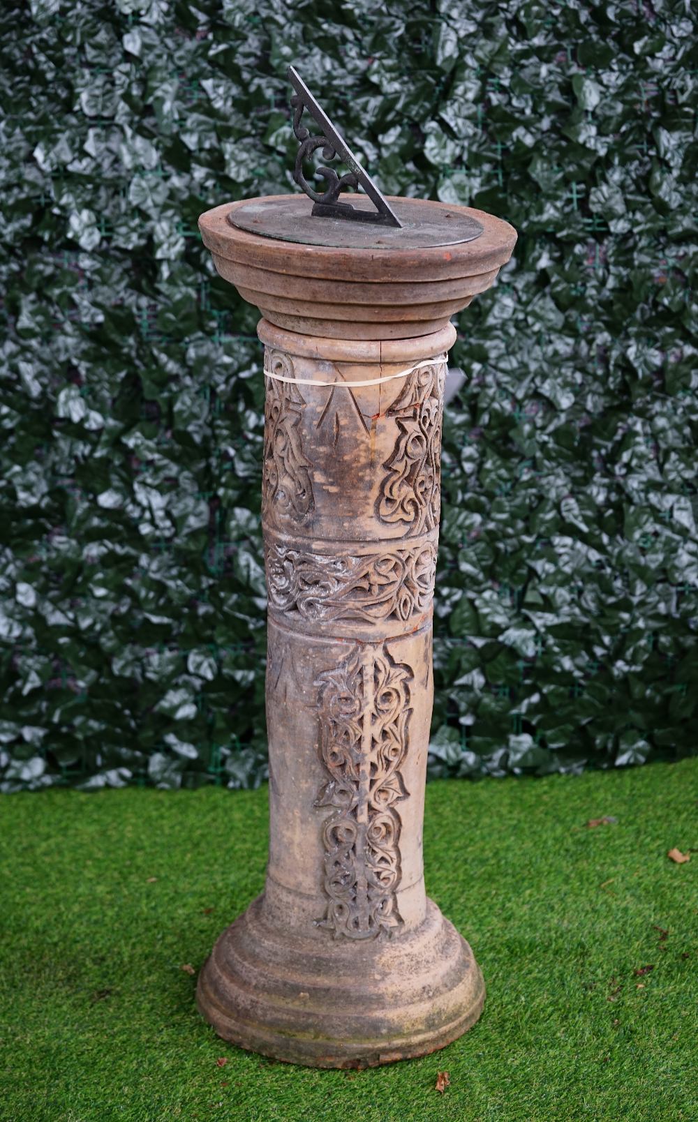 A terracotta sundial with wriggle work column on stepped base, 38cm diameter x 105cm high.