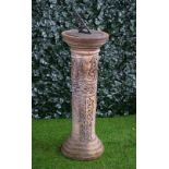 A terracotta sundial with wriggle work column on stepped base, 38cm diameter x 105cm high.