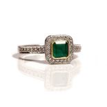 An 18ct white gold, emerald and diamond cluster ring,