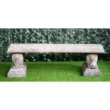 A reconstituted stone curved garden bench, on a pair of recumbent lion supports,