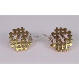 A pair of 18ct white and yellow gold and diamond set earclips of abstract lattice design,