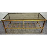 A mid-20th century smoked glass and lacquer brass suite of three coffee tables,