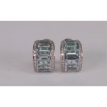 A pair of precious white metal, aquamarine and diamond set earclips of half hoop design,