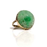 A 9ct gold mounted jade ring, the circular Asian jade with carved and pierced decoration,