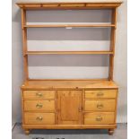 A Victorian pine dresser, the open shelves above a cupboard and six drawers,