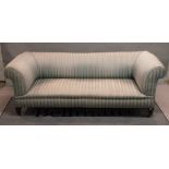 An early 20th century Chesterfield sofa with rollover arms on tapering square supports,