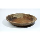 A large shallow turned hardwood fruit bowl, 59cm diameter x 11cm high.