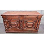 A 17th cenury oak coffer, with raised geometric panelling, divided by split turned columns,