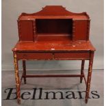 An early 20th century red painted pine dressing table on faux bamboo turned supports,