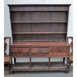 A George III oak dresser, the boarded shelved rack with iron hooks,