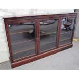 An Edwardian mahogany dwarf bookcase, with adjustable shelves enclosed by three glazed doors,