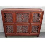 A late 19th century Chinese hardwood side cabinet fronted with six pierced scroll panels,