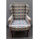 A George I style wingback armchair on shell capped supports and pad feet, 80cm wide x 117cm high.