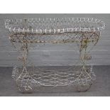 An Edwardian white painted wirework oval two tier plant stand, 95cm wide x 87cm high.