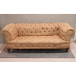A late Victorian mahogany framed Chesterfield sofa with button back upholstery on ring turned