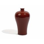 A Chinese flambé glazed porcelain vase, of slender baluster form covered in a deep red glaze, 20.