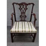 A George III mahogany open armchair, with foliate carved frame and pierced splat,