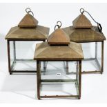 A set of three modern square copper glazed lanterns, 63cm high (3).