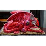 A fairground model of a dragon decorated in red and pink glitter, the head articulating,