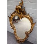 An early 20th century gilt framed trefoil shaped wall mirror with 'C' scroll crest,