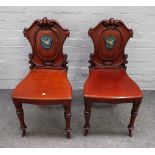 A pair of early 19th century mahogany cartouche back hall chairs,