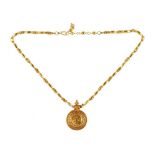An Asian gold pendant necklace, the circular pendant decorated with a beaded border,