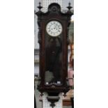 A late 19th century mahogany Vienna style regulator wall clock, the arched top with turned finials,