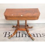 A Victorian walnut foldover card table on fluted column and four downswept supports,