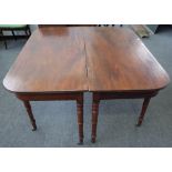 A late George III mahogany rounded rectangular extended dining table on turned supports with two