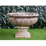 A reconstituted stone oval jardiniere with lobed body on turned socle, 66cm wide x 50cm high.