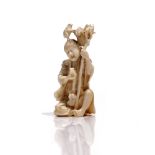 A Japanese ivory okimono, Meiji period, carved as a man seated with toads,