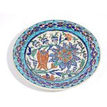 An Iznik style earthenware dish, probably late 19th century, painted with a tulip,