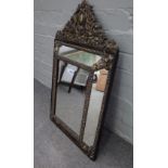 A 19th century Dutch repousse brass cushion framed mirror with arched crest, 46cm wide x 74cm high.