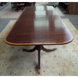 A George III style satinwood banded mahogany triple pillar extending dining table,