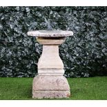 A cast bronzed sundial on a stone square baluster column,